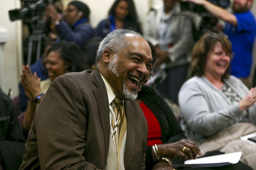 In this Wednesday, March 14, 2018 photo, Gregory Weatherspoon laughs after being named the new school interim superintendent at a special school board meeting at the Flint Community Schools Administrative Building, in Flint, Mich. (Henry Taylor /The Flint Journal-MLive.com via AP)