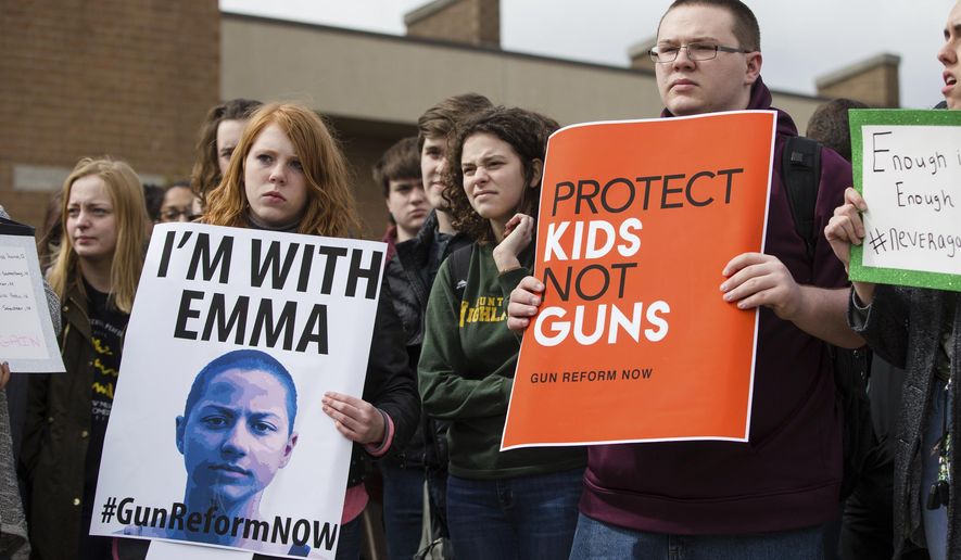 Students at Huntington High School participate in an organized walk-out protest joining students across the nation to raise awareness about gun violence in schools on Wednesday, March 14, 2018, in Huntington, W. Va. The national walk out was also in honor of the 17 victims of the Marjory Stoneman Douglas High School massacre that occurred on Feb. 14. (Sholten Singer /The Herald-Dispatch via AP)