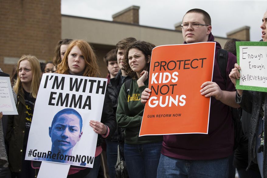 Students at Huntington High School participate in an organized walk-out protest joining students across the nation to raise awareness about gun violence in schools on Wednesday, March 14, 2018, in Huntington, W. Va. The national walk out was also in honor of the 17 victims of the Marjory Stoneman Douglas High School massacre that occurred on Feb. 14. (Sholten Singer /The Herald-Dispatch via AP)