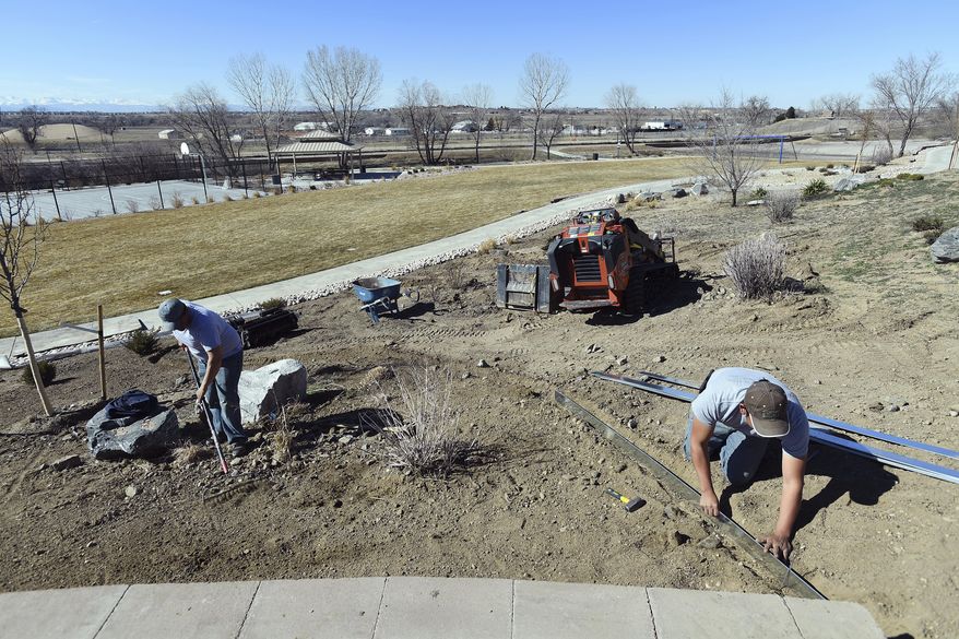 Juan Herrera, left, and Gonzalo Lamen of Singing Hill Landscape work on a park at the Riverdale Dunes community on March 7, 2018 in Commerce City, Colo. Landscapers rely heavily on the H-2B visa program for peak season help. (John Leyba/The Denver Post via AP)