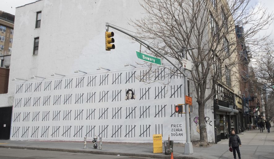 A pedestrian walks past a mural by British artist Banksy protesting the imprisonment of Turkish artist Zehra Dogan, Friday, March 16, 2018, in New York. (AP Photo/Mary Altaffer)