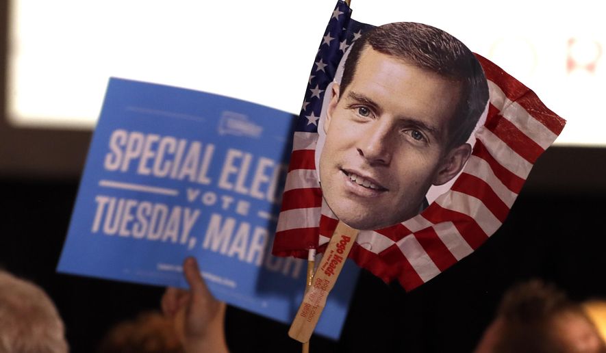Supporters of Conor Lamb, the Democratic candidate for the March 13 special election in Pennsylvania's 18th Congressional District hold signs during his election night party in Canonsburg, Pa., Wednesday, March 14, 2018. Rattled Republicans were hit with the reality check Wednesday in the startling strong performance of a fresh-faced Democrat deep in Trump country. (AP Photo/Gene J. Puskar)