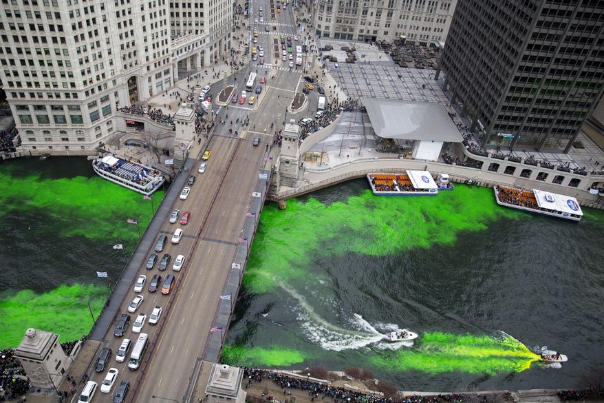 Boats move through the water as the Chicago River is dyed green for St. Patrick's Day Saturday, March 17, 2018, in Chicago. Thousands of people lined the riverfront downtown Chicago to see the dyeing, a tradition for the holiday that dates to 1962. (Erin Hooley/Chicago Tribune via AP)