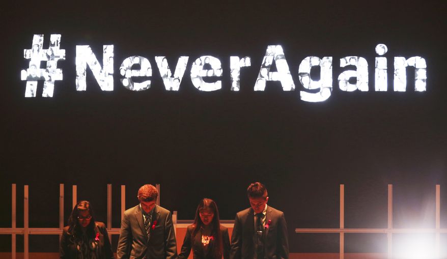 Moderator Vijita Patel, left, joins Parkland High School students Lewis Mizen, second left, Suzanna Barna, third left, and Kevin Trejos, right, in a moment of silence at the Global Education and Skills Forum in Dubai, United Arab Emirates, Saturday, March 17, 2018. Student survivors of a Florida high school shooting took their message calling for greater gun safety measures abroad for the first time on Saturday, sharing with educational professionals from around the world their frightening experience. (AP Photo/Jon Gambrell)