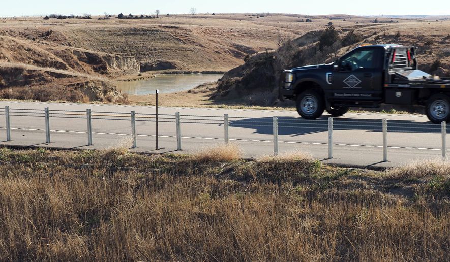 In this Tuesday, Dec. 5, 2017 photo, a vehicle drives near an area where water diverted from the Platte River would flow from a canal on the near side of Nebraska Highway 23 into the canyons on the far side of the road and into Turkey Creek in Smithfield, Neb. (David Hendee/Omaha World-Herald via AP)