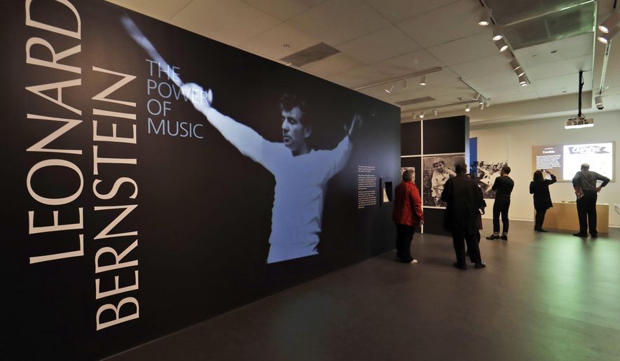 In this Wednesday, March 14, 2018 photo, journalists walk through the Leonard Bernstein exhibit during a press preview at the National Museum of American Jewish History in Philadelphia. The exhibit on the acclaimed composer and conductor opens March 16 and runs through Sept. 2, 2018. (AP Photo/Matt Slocum)