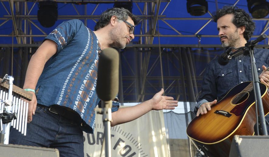 FILE - In a Saturday, July 23, 2015 file photo, The Flight of the Conchords Bret McKenzie, right, and Jemaine Clement perform at the 2016 Newport Folk Festival in Newport, R.I. The music comedy group Flight of the Conchords has postponed a series of tour dates after Bret McKenzie injured his hand in what he called a “very rock ‘n’ roll injury _ falling down some stairs.” In a statement on the band’s website Sunday, March 18, 2018, McKenzie said the upcoming United Kingdom tour of the Flight of the Conchords would be rescheduled after he broke two bones in his hand.  (Jim Rassol/South Florida Sun-Sentinel via AP, File)