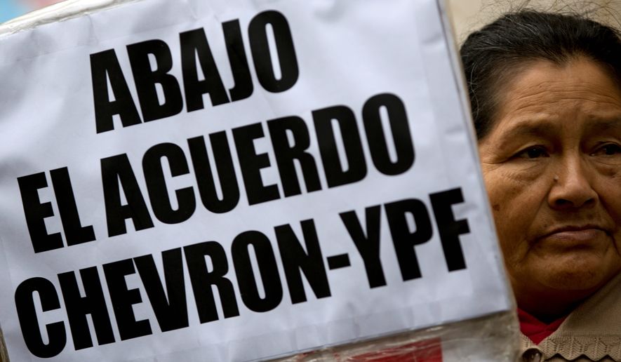 A woman holds a banner that reads in Spanish; &quot;Down with the Chevron- YPF agreement,&quot; during a protest in Buenos Aires, Argentina, Wednesday, May 21, 2014. Demonstrators gathered to protest against a joint venture between YPF and Chevron to use hydraulic fracturing or &quot;fracking&quot; at a major shale oil and gas deposit known as &quot;Vaca Muerta.&quot; (AP Photo/Natacha Pisarenko)