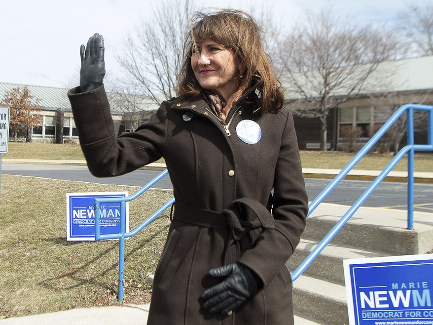 Marie Newman, 3rd district Democratic candidate, waves to a supporter as she stands in front of Kolmar Elementary School in Oak Lawn, Ill., on Tuesday, March 20, 2018. Newman is challenging seven-term Democratic Rep. Dan Lipinski. (Leslie Adkins/Chicago Sun-Times via AP)