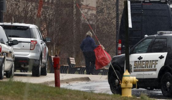 A bag is removed and taken to the crime scene van at Great Mills High School, the scene of a shooting, Tuesday, March 20, 2018, in Great Mills. A student with a handgun shot two classmates inside the school before he was fatally wounded during a confrontation with a school resource officer, a sheriff said.  (AP Photo/Alex Brandon)