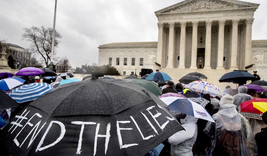 A pro-abortion rights supporter holds an umbrella that reads "#EndTheLies" during a rally outside the Supreme Court in Washington, Tuesday, March 20, 2018, as the Supreme Court hears arguments in a free speech fight over California's attempt to regulate anti-abortion crisis pregnancy centers. (AP Photo/Andrew Harnik)