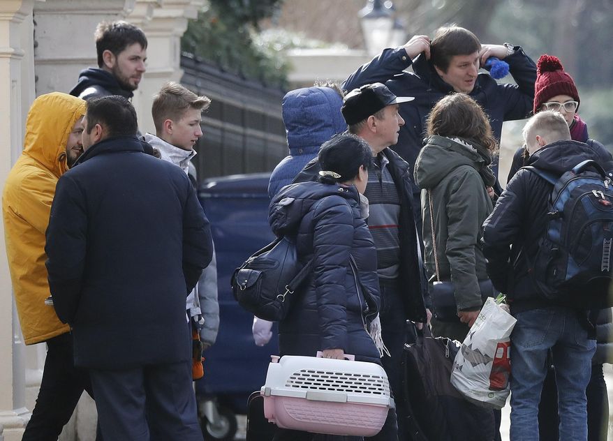 People with suitcases leave the Russian Embassy in London, Tuesday, March 20, 2018. Moscow is awaiting nearly two dozen Russian diplomats ordered to leave Britain as part of a standoff over a nerve agent attack on British soil. (AP Photo/Frank Augstein)