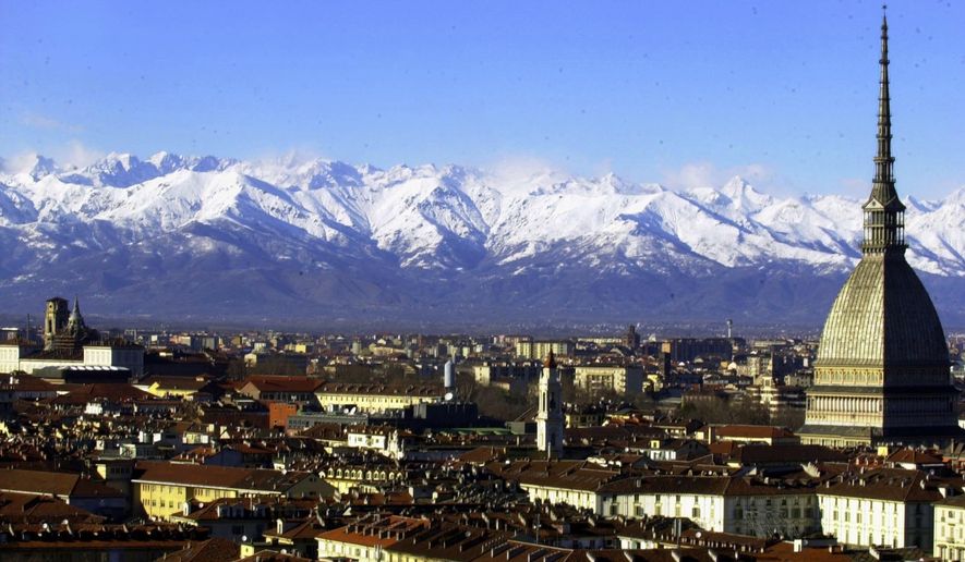 FILE -- A view of Turin, Italy, with the main city landmark, the Mole Antonelliana, at right, and the Alps in background are seen in this December 2005 photo. Milan and Turin are in discussions with the Italian Olympic Committee over a possible bid for the 2026 Winter Games. Turin Mayor Chiara Appendino sent a letter of interest to CONI on Sunday despite divisions in her own party, the populist 5-Star Movement, on a candidacy. (AP Photo/Massimo Pinca)
