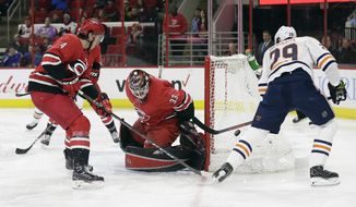 Carolina Hurricanes&#39; Haydn Fleury (4) and goalie Scott Darling (33) defend the goal against Edmonton Oilers&#39; Leon Draisaitl, of Germany, during the first period of an NHL hockey game in Raleigh, N.C., Tuesday, March 20, 2018. (AP Photo/Gerry Broome)