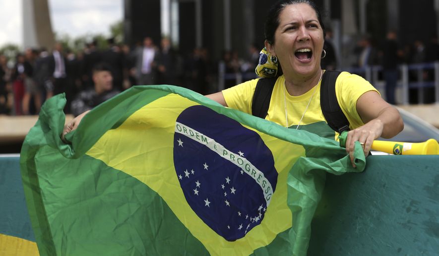 A woman waves a Brazilian flag outside the Supreme Court in favor of arresting former Brazilian President Luiz Inacio Lula da Silva in Brasilia, Brazil, Thursday, March 22, 2018. Da Silva launched a book last week in which he says he is &quot;ready&quot; to go to jail and serve a 12-year and one-month sentence on a corruption charge conviction. (AP Photo/Eraldo Peres)