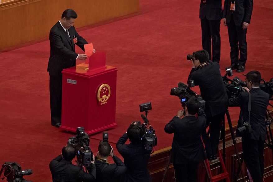 In this Saturday, March 17, 2018, photo, Chinese journalists film Chinese President Xi Jinping casts his ballot during a plenary session of China's National People's Congress at the Great Hall of the People in Beijing. The Chinese Communist Party's move to exert direct control over state broadcasters and regulators of everything from movies and TV to books and radio programs shows the party's drive to use the media for ideological efforts at home and to improve its image overseas, analysts say. The move is part of a push by Xi to tighten party supervision over much of Chinese public life as he renews his uncontested rule free of constitutional limits on his terms in office. (AP Photo/Andy Wong)