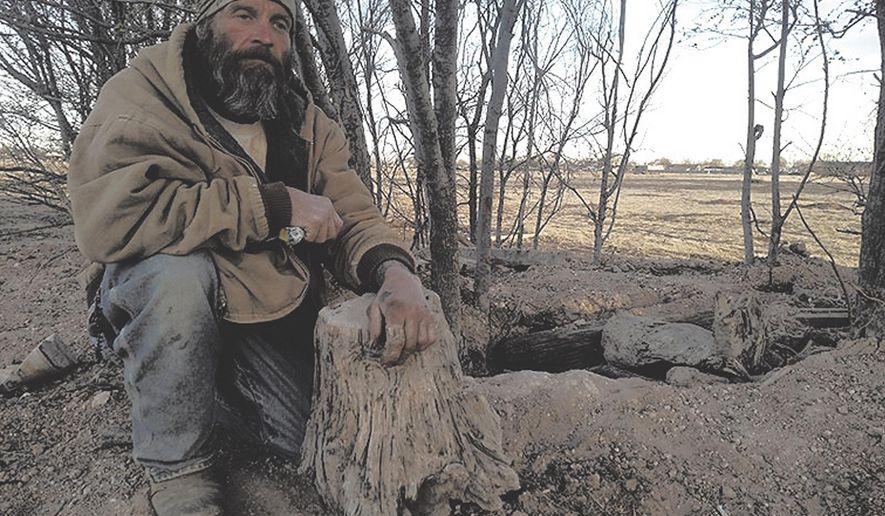 The entrance to Sean Heron's hole-in-the-ground is a discreet opening in the earth with a rope tied to a tree for support. Heron says homelessness drove him to seek shelter underground. (David Grieder/The Eastern New Mexico News via AP)