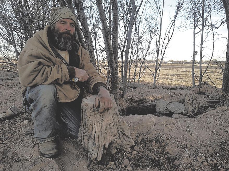 The entrance to Sean Heron's hole-in-the-ground is a discreet opening in the earth with a rope tied to a tree for support. Heron says homelessness drove him to seek shelter underground. (David Grieder/The Eastern New Mexico News via AP)