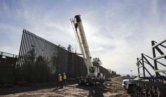 In this March 5, 2018, photo, construction continues on a new, taller version of the border structure in Calexico, Calif. Congress gave President Donald Trump the $1.6 billion he sought for one year of funding of the border wall with Mexico, but he wanted a long-term wall financing commitment. (AP Photo/Gregory Bull)