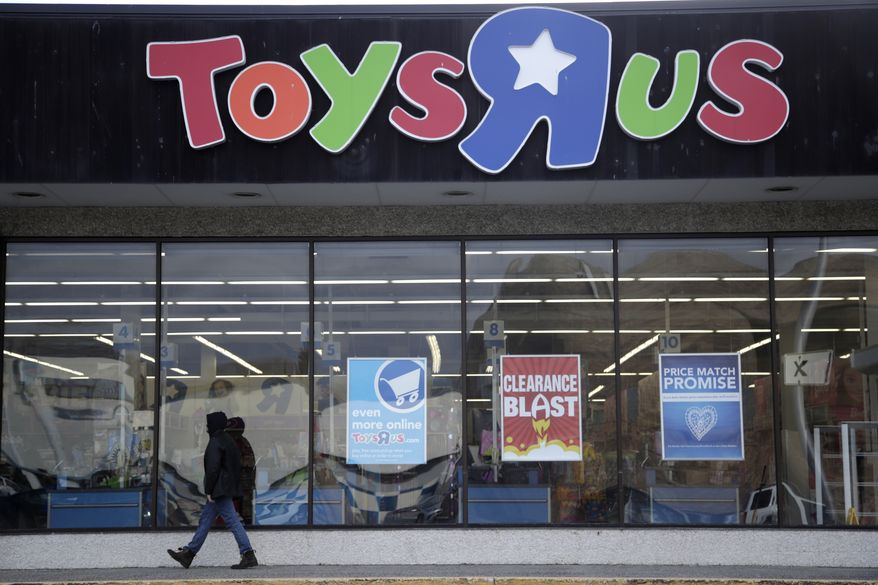 FILE- This Jan. 24, 2018, file photo shows a person walking near the entrance to a Toys R Us store, in Wayne, N.J. Toys R Us is opening its doors with a going-out-of-business sale, offering clearance discounts at all 735 stores, including Babies R Us. The company did not say Friday, March 23, how big the discounts will be or when it expects stores to shut down. (AP Photo/Julio Cortez, File)