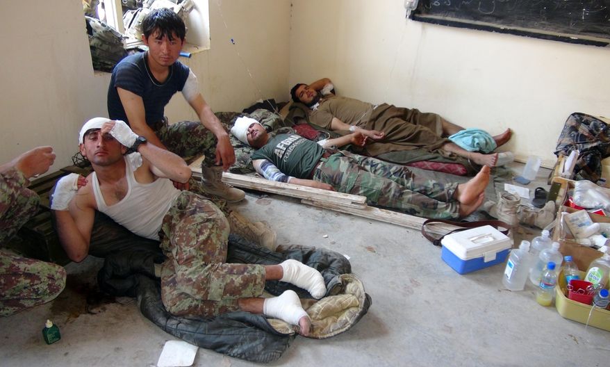 FILE - In this Monday, July 20, 2015 file photo Afghanistan National Army wounded soldiers lie on the ground as they receive treatment, in district of Baraki Barak in Logar province, east of Kabul, Afghanistan. Sloppy blood collection and identification by Afghanistan's army may have led to the deaths of injured soldiers who received the wrong blood type, a U.S. watchdog said. Its report also questioned whether blood was being properly tested for disease. (AP Photo/Ihsanullah Mahjoor, File)