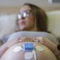 In this Wednesday, Feb. 21, 2018 photo, Serena Esplin, a labor and delivery nurse, wears the Monica Novii, a wireless heart rate and contraction monitor, at East Idaho Regional Medical Center in Idaho Falls, Idaho. The wireless system allows tracking of the heart rate of both the mother and baby as well as uterine contractions in a small package that also allows the mother to be more mobile than with other wired systems. (John Roark/The Idaho Post-Register via AP)