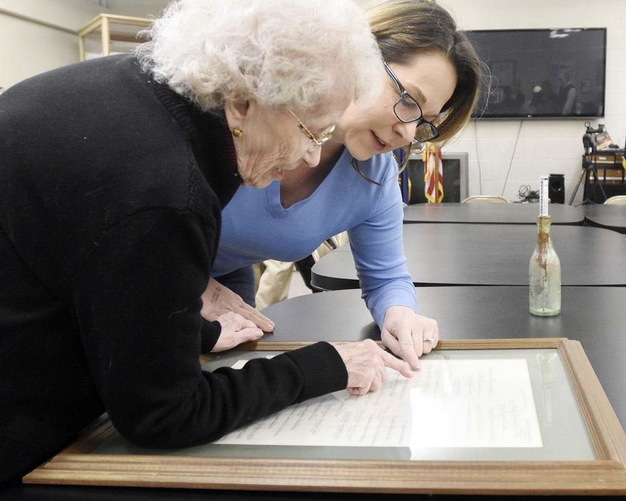 In this Thursday, March 15, 2018 photo, Wilma Martin, left, shows Brenda Harris, a fellow great, great, great, great granddaughter of Elizabeth Rawlings (Hart) Gunterman, Martin's, family tree including Gunterman during a first-time meeting of the two relatives at the Hardin County History Museum in Elizabethtown, Ky. Gunterman's first husband, Miles Hart, was killed by American Indians and Gunterman and three of her children were captured. Two of the children were killed and one was separated from his mother and later rescued by his uncles, Harris said. (Jill Picket/The News-Enterprise via AP)
