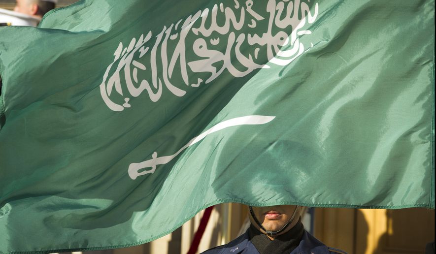 A Honor Guard member is covered by the flag of Saudi Arabia as Defense Secretary Jim Mattis welcomes Saudi Crown Prince Mohammed bin Salman to the Pentagon with an Honor Cordon, in Washington, Thursday, March 22, 2018. (AP Photo/Cliff Owen)