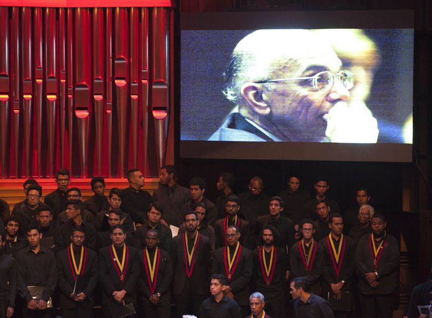 CORRECTS AGE - A picture of music educator Jose Antonio Abreu is displayed during his wake at an auditorium in Caracas, Venezuela, Sunday, March 25, 2017. Abreu, founder of Venezuela's network of youth orchestras known as 'El Sistema' or The System, died at age 78 on Saturday, March 24. (AP Photo/Ariana Cubillos)