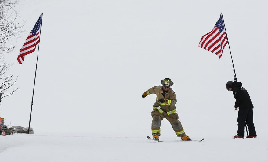 Rumford, Maine firefighter Ray Crockett charge across the starting line while competing in the individual class race during the Masters of the Hose ski race at the Sunday River ski resort, Sunday, March 25, 2018, in Newry, Maine. The 28th annual race raises money for the Sunday River Community Fund. The fund supports charitable organizations in neighboring communities. (AP Photo/Robert F. Bukaty)