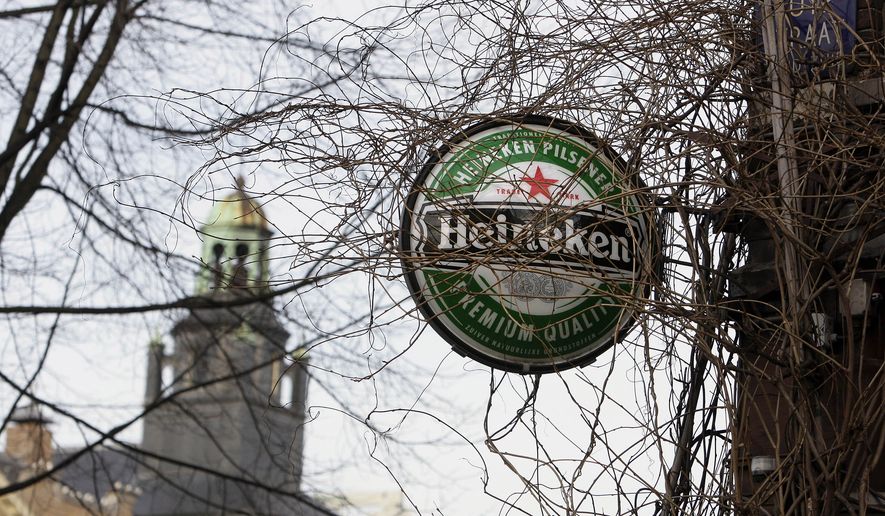 Heineken sign near a cafe in Amsterdam, Netherlands, Friday, Jan. 25, 2008. Brewers Carlsberg and Heineken will buy beermaker Scottish &amp; Newcastle for $15.3 billion, (euro10.4 billion)  the companies said. If the deal goes through, Copenhagen-based Carlsberg A/S would gain sole ownership of Baltic Beverages and S&amp;N&#x27;s French, Greek and Chinese operations, while Amsterdam-based Heineken NV would take control of its British, American, Indian and other markets. (AP Photo/ Evert Elzinga)