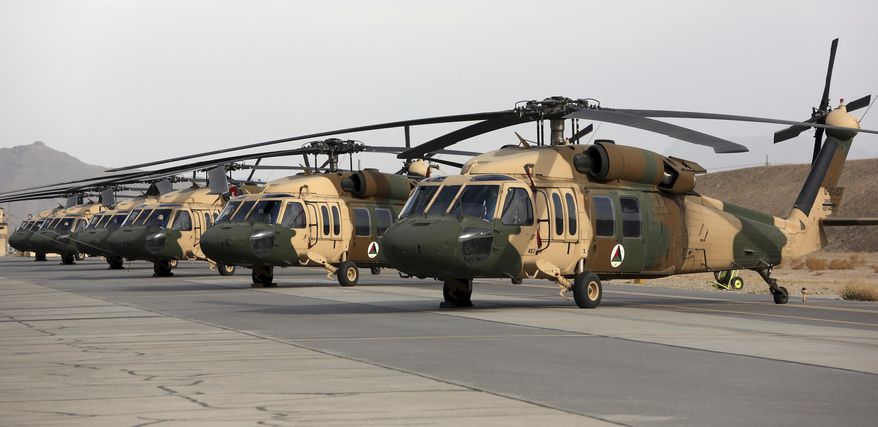 In this Monday, March 19, 2018, file photo, UH-60 Black Hawk helicopters are parked at Kandahar Air Field, Afghanistan. The U.S. military has been flying UH-60 Black Hawk helicopter missions in Afghanistan for years, but the storied aircraft will soon take to the country’s battlefields manned by pilots and crews from the Afghan military. (AP Photo/Rahmat Gul)