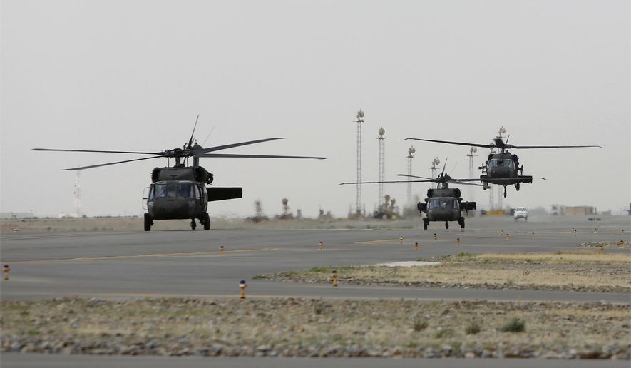 In this Monday, March 19, 2018 photo, UH-60 Black Hawk helicopters carrying US advisors and Afghan trainees take off from Kandahar Air Field, Afghanistan. The U.S. military has been flying UH-60 Black Hawk helicopter missions in Afghanistan for years, but the storied aircraft will soon take to the country’s battlefields manned by pilots and crews from the Afghan military. (AP Photo/Rahmat Gul)
