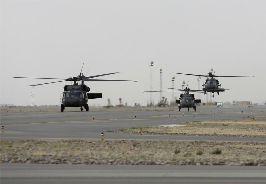 In this Monday, March 19, 2018 photo, UH-60 Black Hawk helicopters carrying US advisors and Afghan trainees take off from Kandahar Air Field, Afghanistan. The U.S. military has been flying UH-60 Black Hawk helicopter missions in Afghanistan for years, but the storied aircraft will soon take to the country’s battlefields manned by pilots and crews from the Afghan military. (AP Photo/Rahmat Gul)