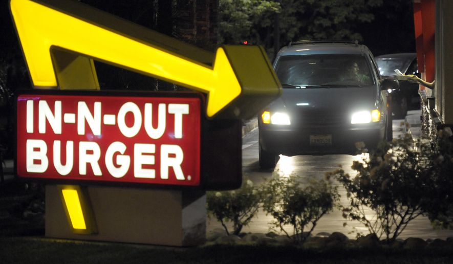 In this June 8, 2010, file photo, a customer receives an order from the drive-through at an In-N-Out Burger. (AP Photo/Adam Lau, File)