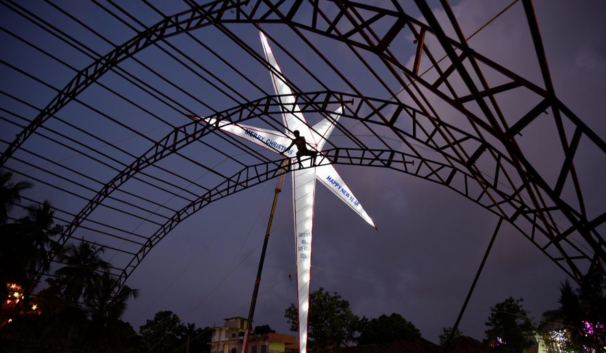 In this Dec. 23, 2017, file photo, an worker is silhouetted as he prepares a temporary structure for Christmas and New Year celebrations in Thiruvananthapuram, Kerala state, India. Though Christians make up only about two percent of India&#x27;s 1 billion-plus population, Christmas is a national holiday celebrated with much fanfare. (AP Photo/R S Iyer, File)