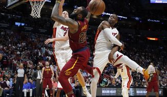 Miami Heat guard Dwyane Wade, right, blocks a shot by Cleveland Cavaliers forward LeBron James (23) in the first quarter during an NBA basketball game, Tuesday, March 27, 2018, in Miami. At left is Heat forward Kelly Olynyk (9). (AP Photo/Joe Skipper)