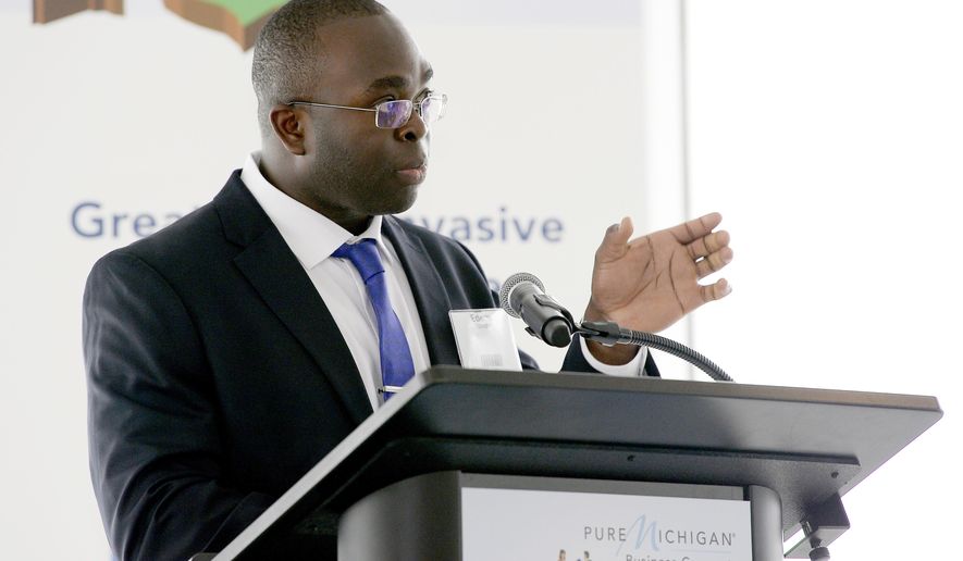 Edem Tsikata, a software consultant from Boston, gives his presentation 'A Cavitation Barrier to Deter Asian Carp,' during the Carp Tank event Tuesday, March 27, 2018, in Detroit. His presentation won the competition (Clarence Tabb Jr./Detroit News via AP)