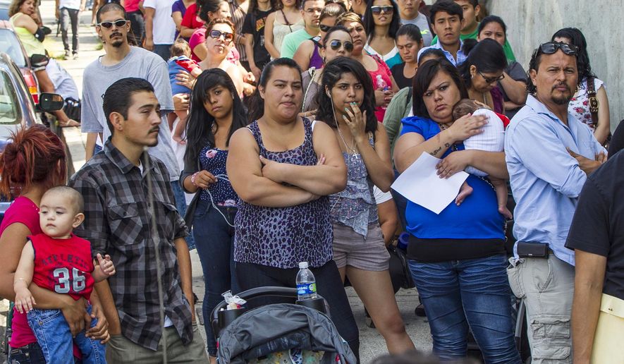 FILE - In this Aug. 15, 2012, file photo, a line of people living in the U.S. without legal permission wait outside the Coalition for Humane Immigrant Rights in Los Angeles. California is suing the Trump administration over its decision to add a question about citizenship to the 2020 U.S. Census. In announcing the lawsuit Tuesday, March 27, 2018, California Attorney General Xavier Becerra says adding such a question is a reckless decision that would violate the U.S. Constitution and cause a population undercount. (AP Photo/Damian Dovarganes, File)