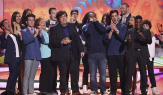 FILE - In this March 29, 2014, file photo, Dan Schneider, center, accepts the lifetime achievement award at the 27th annual Kids&#39; Choice Awards at the Galen Center in Los Angeles. Nickelodeon is breaking ties with Schneider, the creator of some of its top shows, including “Henry Danger” and “iCarly.” In a joint statement, Nickelodeon, Schneider and his production company, Schneider’s Bakery, agreed it “is a natural time” to pursue other opportunities and projects since several Schneider’s Bakery projects are wrapping up. (Photo by Matt Sayles/Invision/AP, File)