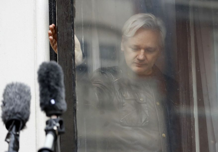 In this May 19, 2017, file photo, WikiLeaks founder Julian Assange closes a window after greeting supporters from the balcony of the Ecuadorian embassy in London. (AP Photo/Frank Augstein, File)