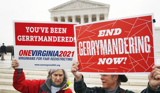 Sara Fitzgerald, left, and Michael Martin, both with the group One Virginia, protest gerrymandering in front of the Supreme Court, Wednesday, March 28, 2018, in Washington where the court will hear arguments on a gerrymandering case. (AP Photo/Jacquelyn Martin)