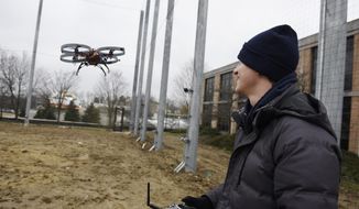 Matthew Romano, 1st year PhD Robotics student flies his drone inside the new M-Air netted autonomous aerial vehicle outdoor lab at the University of Michigan on Wednesday, March 28, 2018, in Ann Arbor, Mich. The facility can test drones in just about any kind of weather.  (Clarence Tabb Jr./Detroit News via AP)
