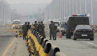 South Korean soldiers wait for vehicles carrying a South Korean delegation at Unification Bridge, which leads to the Panmunjom in the Demilitarized Zone in Paju, South Korea, Thursday, March 29, 2018. The delegation led by Unification Minister Cho Myoung-gyon will hold a high-level talks with North Korea at the northern side of the Panmunjom. (AP Photo/Lee Jin-man)