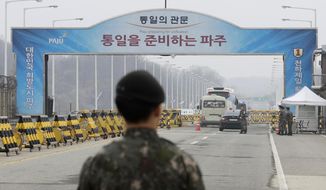South Korean soldiers stand as vehicles carrying a South Korean delegation pass the Unification Bridge, which leads to the Panmunjom in the Demilitarized Zone in Paju, South Korea, Thursday, March 29, 2018. The delegation led by Unification Minister Cho Myoung-gyon will hold a high-level talks with North Korea at the northern side of the Panmunjom. (AP Photo/Lee Jin-man)
