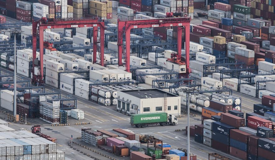 A cargo truck drives amid stacked shipping containers at the Yangshan port in Shanghai, Thursday, March 29, 2018. China&#x27;s Commerce Ministry called on Washington on Thursday to discard planned tariffs it warned might set off a chain reaction that could disrupt global trade and said Beijing will &quot;fight to the end&quot;. (AP Photo)