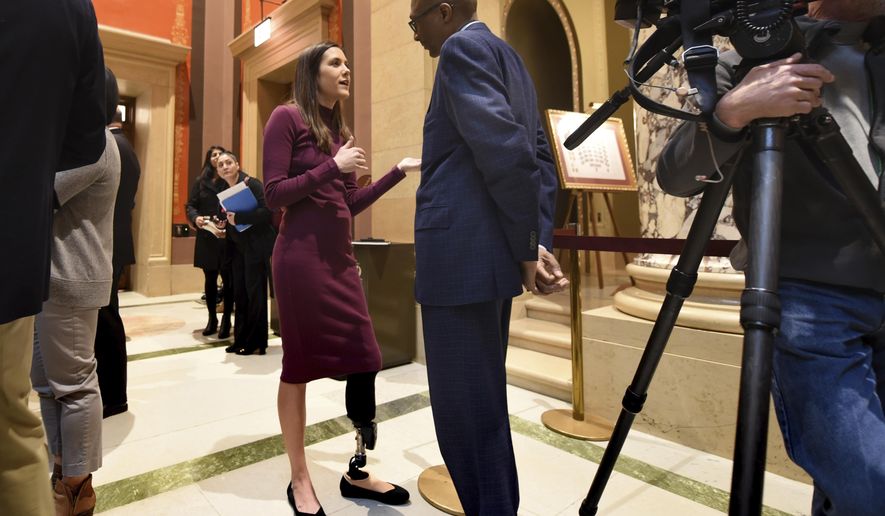 Courtney Godfrey speaks with Minnesota state Sen. Bobby Joe Champion, DFL-Minneapolis, about her push to ban family exclusions for boat liability insurance, outside the Senate chambers at the state Capitol in St. Paul on Monday, March 26, 2018. Godfrey, a Fox-9 reporter who lost her lower left leg in a boating accident on her husband's boat, began advocating for the change after learning she was excluded from her husband's insurance coverage because they're married. (Dave Orrick/Pioneer Press via AP)