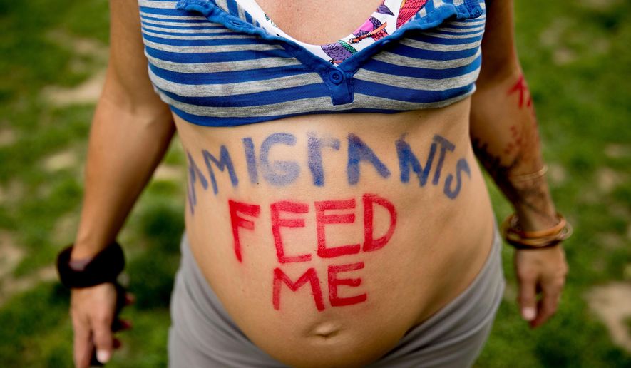 In this May 1, 2017, photo, a pregnant Olivia Tincani of Calif., paints a supportive message to immigrant farmworkers as she joins a large group protesters outside the White House to denounce President Donald Trump&#39;s anti-immigrant policies on May Day in Washington. The Trump administration says pregnant women charged with being in the United States illegally will no longer receive special considerations that allowed them to be released while their cases wind through immigration court, U.S. Immigration and Customs Enforcement said Thursday, March 29, 2018. (AP Photo/Andrew Harnik) **FILE**