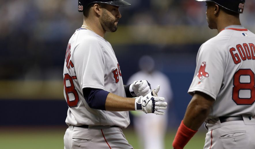 Boston Red Sox's J.D. Martinez, left, shakes hands with first base coach Tom Goodwin after drawing a walk from Tampa Bay Rays starting pitcher Chris Archer during the second inning of a baseball game Thursday, March 29, 2018, in St. Petersburg, Fla. (AP Photo/Chris O'Meara)