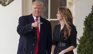 President Donald Trump points to outgoing White House Communications Director Hope Hicks on her last day before he boards Marine One on the South Lawn of the White House in Washington, Thursday, March 29, 2018. (AP Photo/Andrew Harnik)